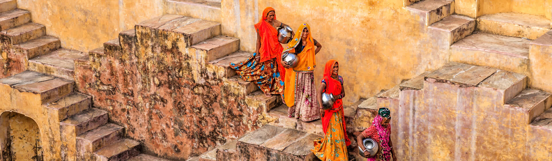 Historic stepwell architecture in rural Rajasthan with local women collecting water