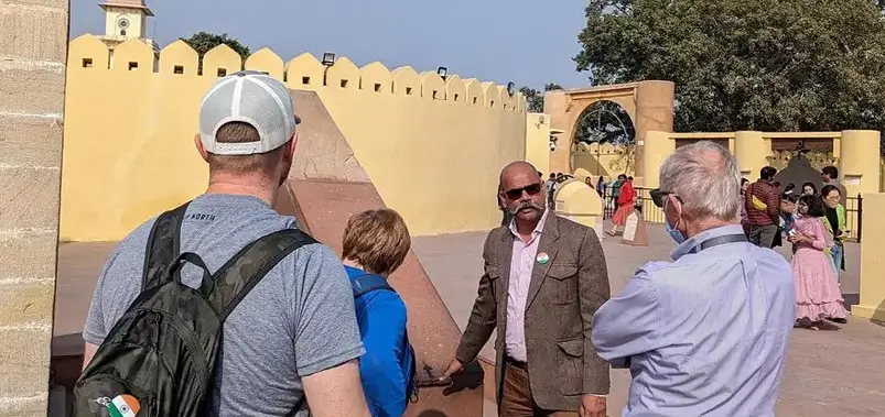 Tourists listening to a local tour guide at the Jantar Mantar observatory in Jaipur, India.